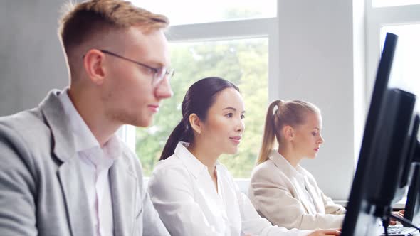 Diverse team of young professionals is working in the phone support office.