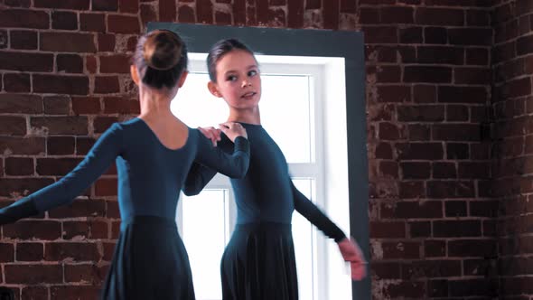 Two Ballerina Girls Dancing in Dark Costumes on Training in the Studio
