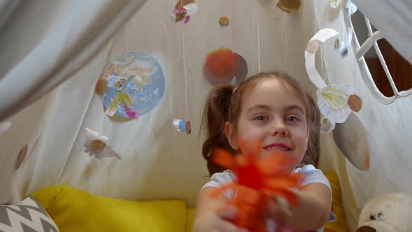 Little Girl Plays Space Aliens at Home Sitting in a Tent