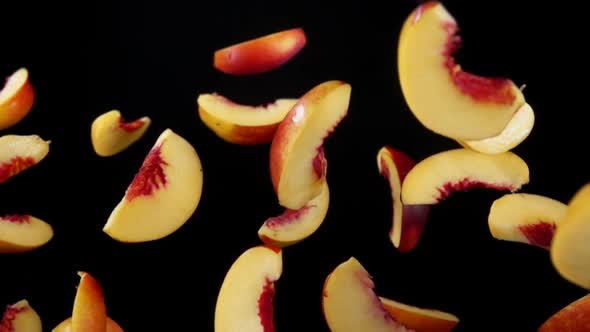 Peach Slices Bounce on a Black Background