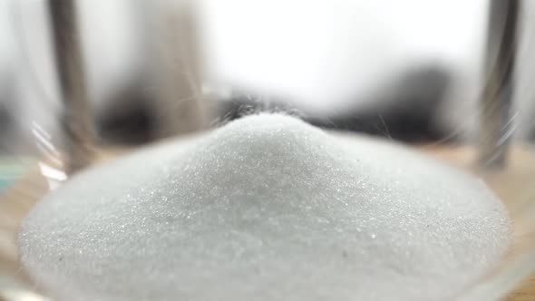 Refined Sugar Falling Onto Pile Inside the Glass Bowl