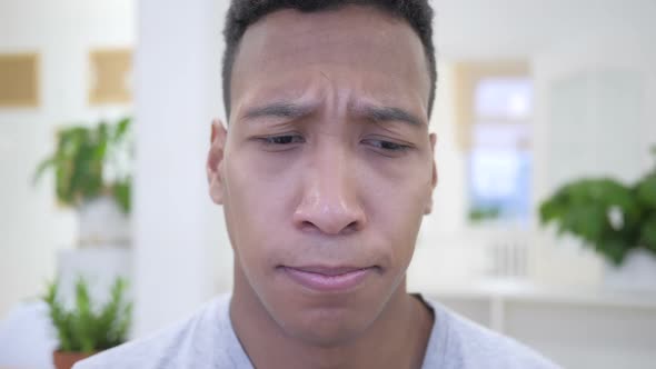 Sad African American Man in Loss Working on Laptop