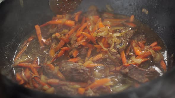Stirring Carrots with Meat for Uzbek Pilaf