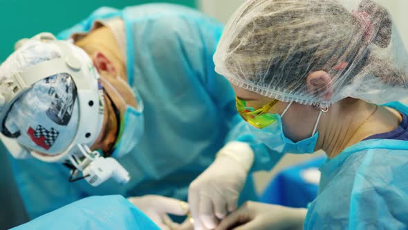 Surgeons During Operation. Plastic surgeons operating patient in clinic