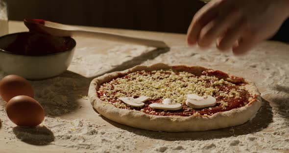 Male Hands of the Chef Preparing a Pizza with Mushrooms