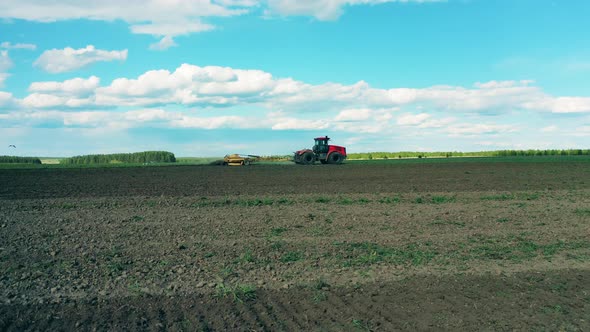 Modern Tractor Sows Seeds on a Field