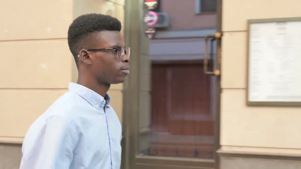 African Man Walking on the Street Side View