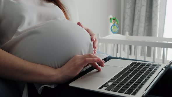 Close Up Futage of Pregnant Woman Resting on a Sofa at Home and Working Remotely with Laptop