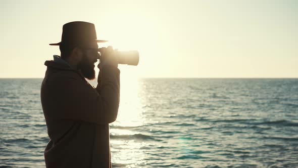 Silhouette of Photographer with Camera on Background of Ocean Surface