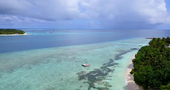 Luxury above travel shot of a sunshine white sandy paradise beach and blue sea background in 4K