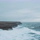 Wild ocean waves crashing againt coastal cliffs and into the caves shot by drone - VideoHive Item for Sale