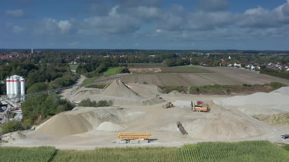 Timelapse of bulldozers working on a construction site with lots of sand at daytime under a blue puf alt