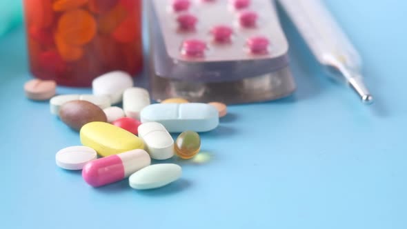 Close Up of Colorful Pills Spilling on Blue Background