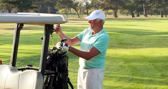Male golfer removing golf club from golf bag