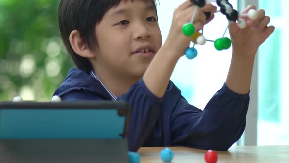 Asian Child Constructing Molecular Model  In Science Classroom