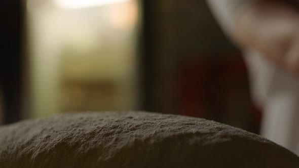 Hand Throwing Flour On Top Of Bread Dough