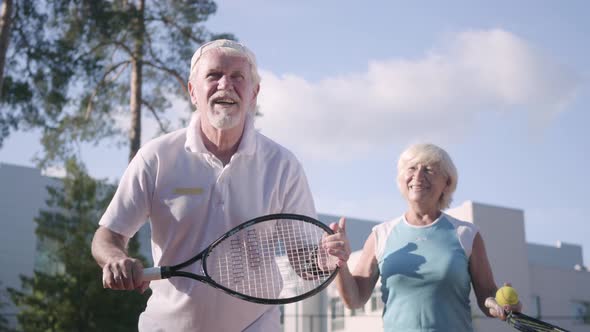 Adult Couple Playing Tennis on a Sunny Day