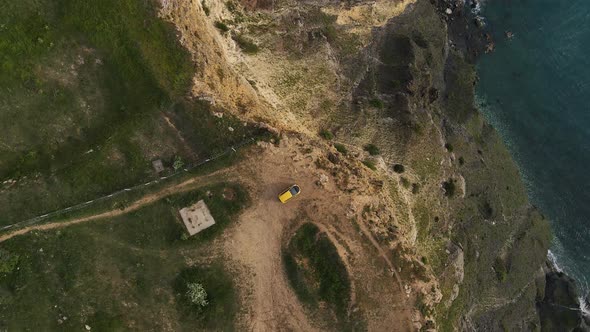 A Yellow Car Stands on the Edge of a Cliff at Cape Lermontov