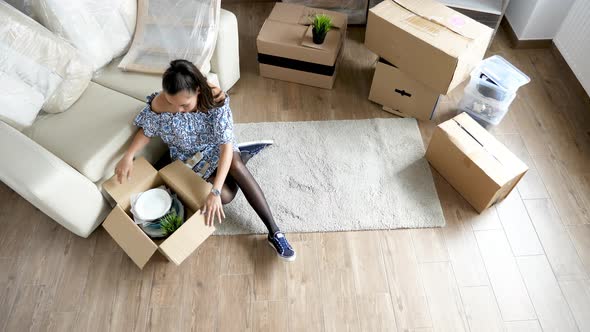 Top View Woman Unpacking From Cardboard Boxes