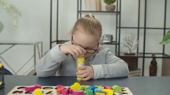 Joyful Girl with Genetic Disorder Playing with Soap Bubbles