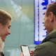 Young Couple Looking at Flight Schedule at Airport - VideoHive Item for Sale