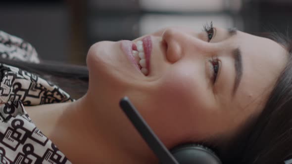 Vertical Video Close Up of Call Center Employee with Headphones Talking on Phone Call