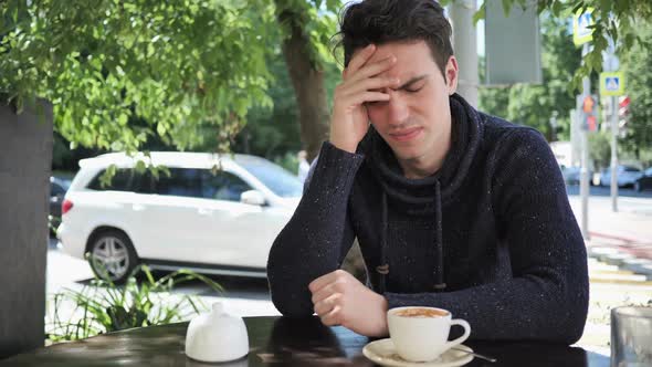 Headache Tense Young Man in Cafe Terrace
