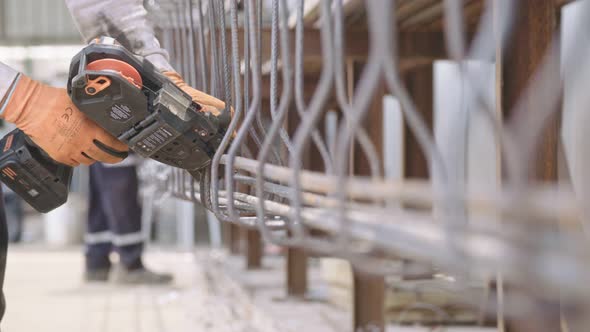 Steel fixers connecting steel rods for concrete reinforcement