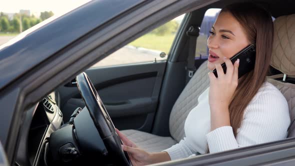 Businesswoman with Long Hair Talks on Smartphone Driving Car