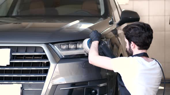 Man Polish a Car in a Garage