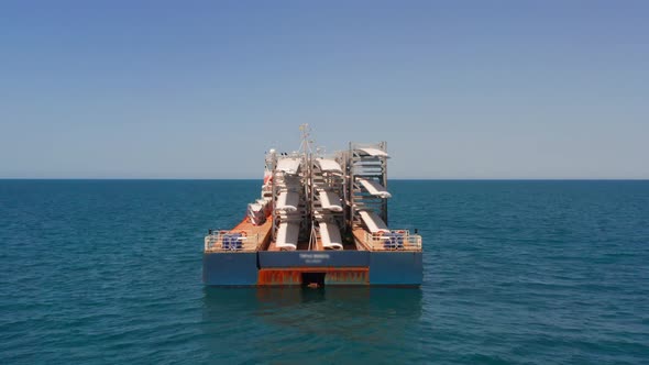 Heavy load carrier ship loaded with Electric Turbine Blades anchored at Sea, Aerial view.