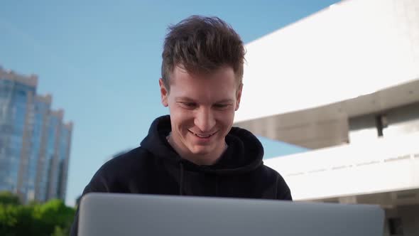 Happy Guy is Using Laptop and Smiling While Enjoying Watching Videos on Internet