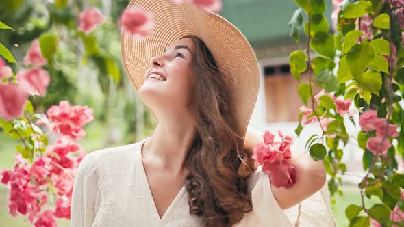 Portrait of a Young Cheerful Caucasian Woman in a Big Straw Hat 