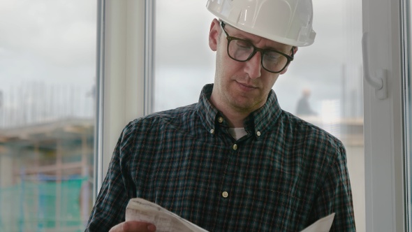 Builder engineer wear security helmet look at blueprint