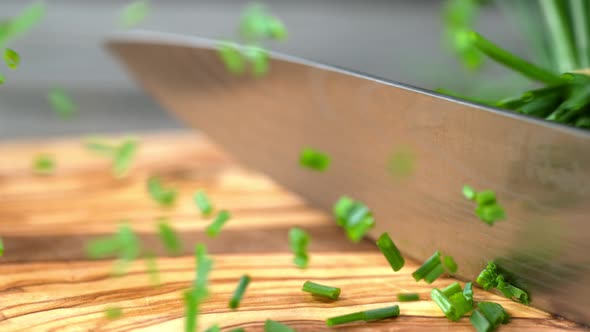 Super Slow Motion Shot of Cutting Chive on Wooden Cutting Board at 1000Fps.