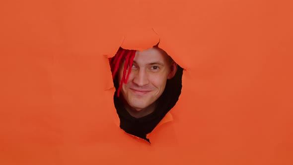 Smiling Man with Red Dreadlocks in Hole in Wall