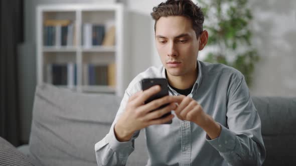 Young Man Using Smartphone at Home