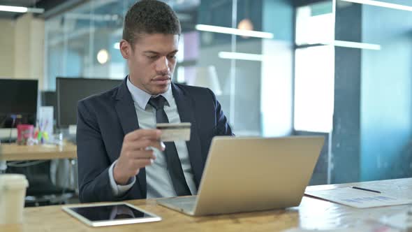 Young African Businessman Using Credit Card on Laptop