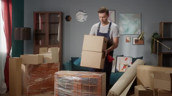Repairman Worker is Preparing Build Furniture in Apartment Placing Boxes and Equipment