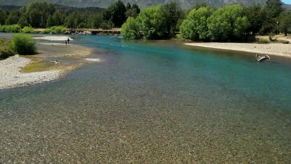 People fly fishing in Cholila River and Lake, Patagonia, Argentina, aerial forward flyover wide shot