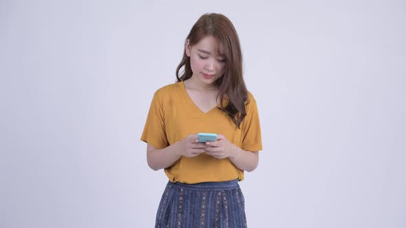 Happy Young Asian Woman Using Phone