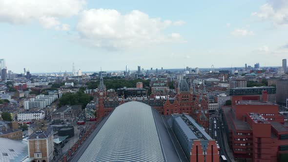 Backwards Fly Above Large Building of St Pancras Train Station