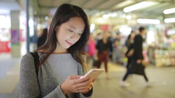 Woman use of smart phone at night in Hong Kong