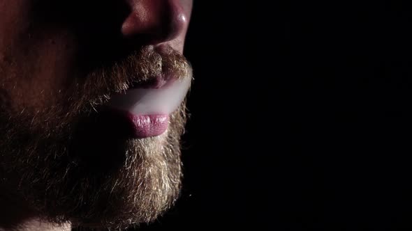 Man Releases Smoke From Mouth. Black. Silhouette. Slow Motion