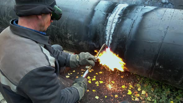 The Welder Cuts Large Metal Pipes with Ocetylene Welding