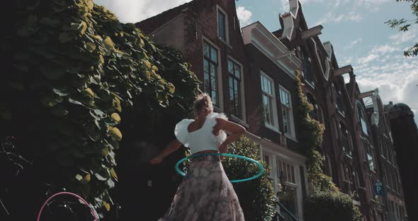 Woman Hula Hoops on sidewalk