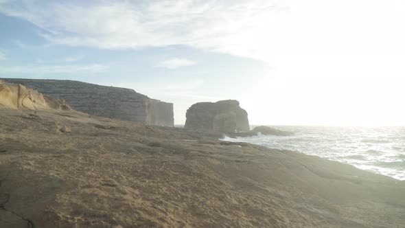 Hazey Look Around Fungus Rock Islet Washed by Strong Mediterranean Sea Waves on Lovely Evening