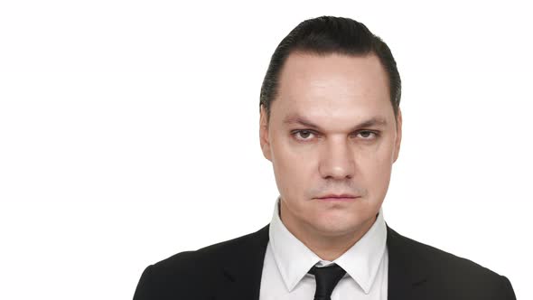 Portrait Closeup of Concentrated Man in Classic Suit Posing Over White Background in Studio with