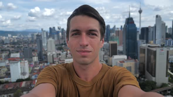 Young Man Taking Selfie on the Roof of Skyscraper