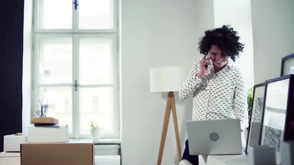 Young online shop owner talking to client on the phone